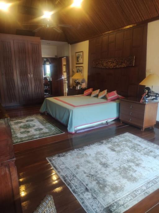 Spacious bedroom with hardwood floors and traditional decor