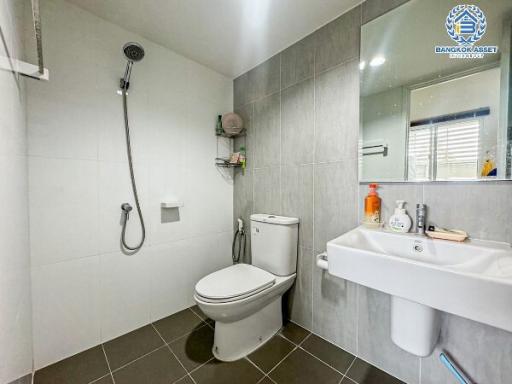 Modern bathroom interior with wall-mounted sink, toilet, and shower