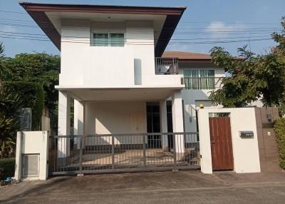 Two-story house with balcony and gated driveway