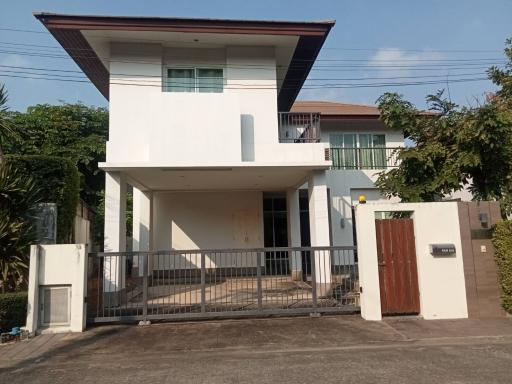 Two-story house with balcony and gated driveway