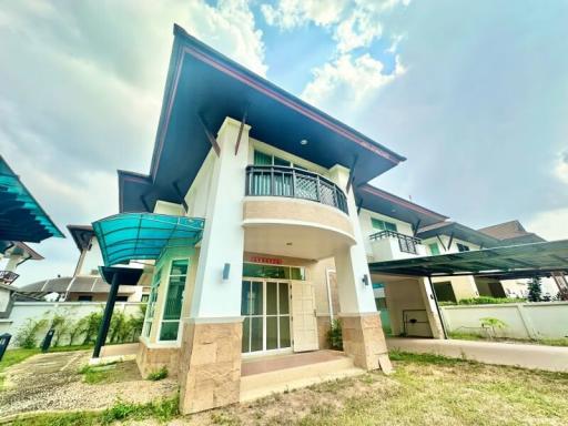 Spacious two-story residential home with a large yard and balcony under a blue sky