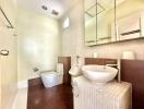 Modern bathroom with beige tiles, sink, mirror, and toilet