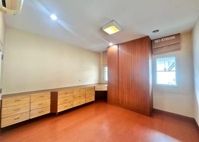 Spacious bedroom with wooden flooring and ample storage space