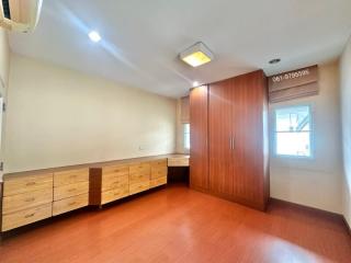 Spacious bedroom with wooden flooring and ample storage space