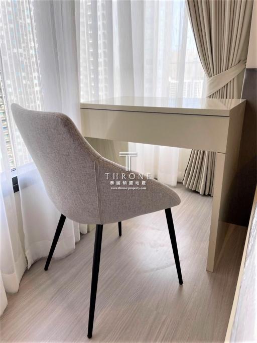 Minimalistic bedroom interior with a modern chair and desk by a window with sheer curtains