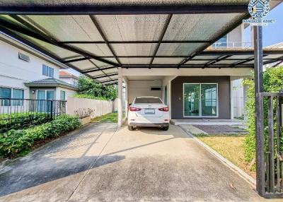 Spacious driveway with a carport and greenery