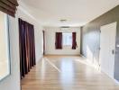 Spacious living room with hardwood flooring and natural light