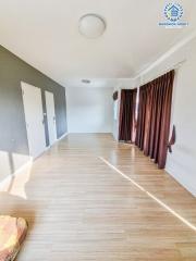 Spacious living room with hardwood flooring and natural light