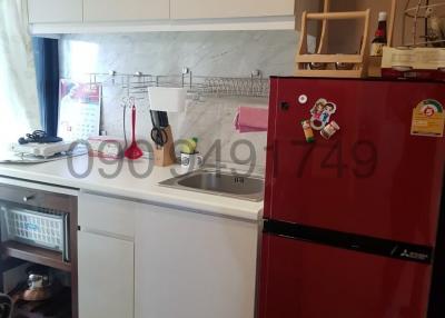 Compact kitchen with white cabinetry and red refrigerator