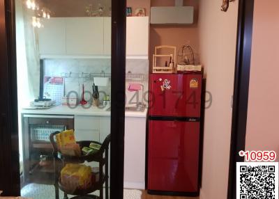 Compact kitchen with red refrigerator and white cabinetry