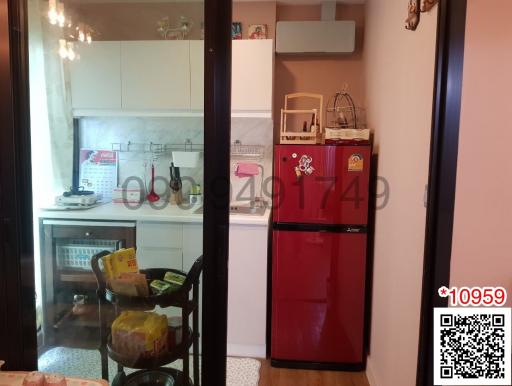 Compact kitchen with red refrigerator and white cabinetry