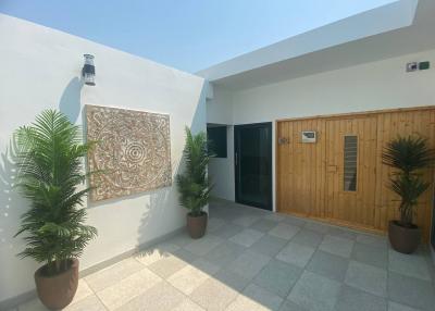 Cozy private patio area with decorative wall art and potted plants