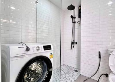 Modern bathroom with washing machine and walk-in shower