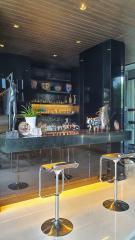 Elegant home bar with modern stools and decorative art pieces