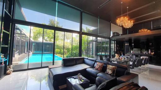 Spacious living room with large windows overlooking a pool