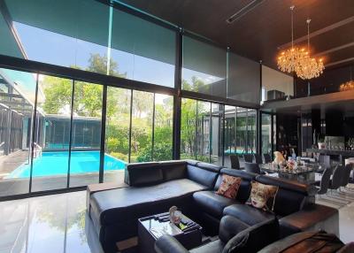 Spacious living room with large windows overlooking a pool