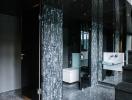 Modern bathroom interior with walk-in shower and black tiles