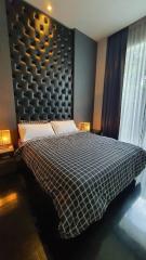 Modern bedroom with a large upholstered headboard and black and white decor