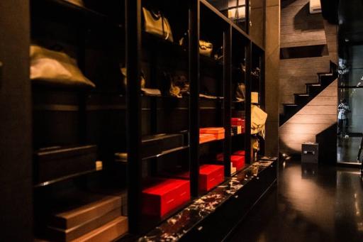 Modern dark-toned hallway with open shelving and stairway