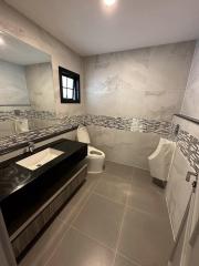 Modern bathroom with neutral color tiles and dark wood vanity
