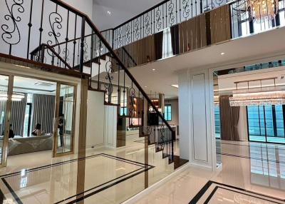 Elegant interior with staircase, high-gloss floor, and chandelier