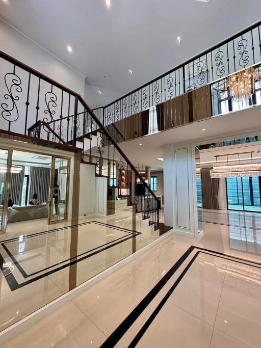 Elegant interior with staircase, high-gloss floor, and chandelier