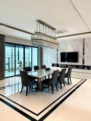 Modern dining room with an elegant table, designer chairs, and a stylish chandelier