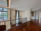 Elegant interior living space with hardwood floors, wrought iron railing, and detailed cornice lighting