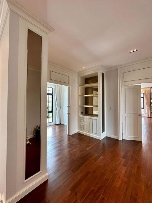 Spacious living room with natural light, hardwood floors, and built-in bookshelves