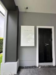 Modern home exterior with Tesla Powerwall installed next to the front door