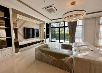 Modern living room with large windows and elegant chandelier