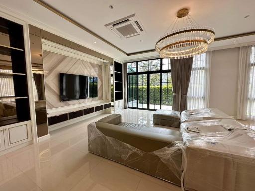 Modern living room with large windows and elegant chandelier