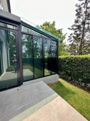 Spacious garden patio with large glass doors and green landscaping