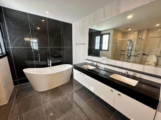 Modern bathroom with freestanding tub, double vanity, and large mirror