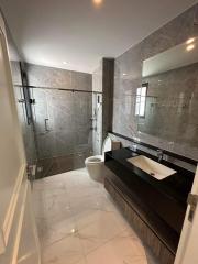 Modern bathroom with marble tiles and glass shower enclosure