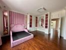 Spacious bedroom with a large pink bed and wardrobes