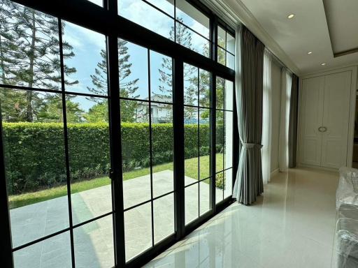 Elegant living room with large windows offering garden and ocean view