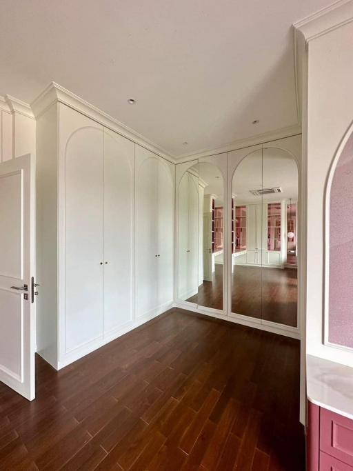 Spacious bedroom with built-in wardrobe and mirrored wall