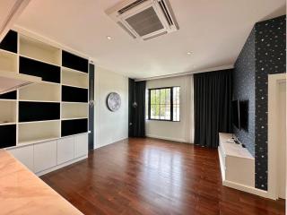 Spacious bedroom with hardwood floors, built-in shelves, and large windows