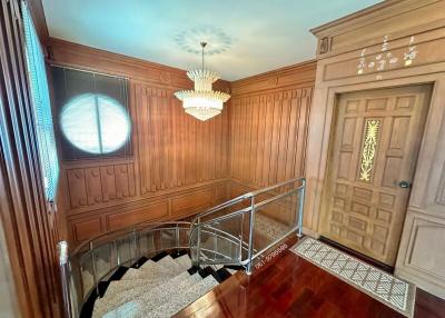 Elegant entryway with wooden paneling and staircase