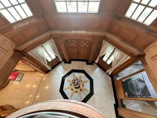 Elevated interior view of a building with detailed ceiling work and a decorative floor design
