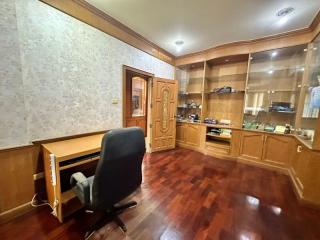 Spacious home office with wooden furniture and hardwood flooring