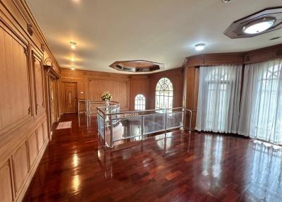 Spacious living room with wooden paneling and hardwood floors