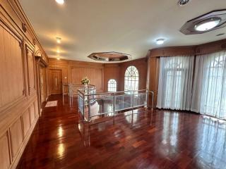 Spacious living room with wooden paneling and hardwood floors