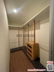 Spacious walk-in closet with wooden shelves and drawers