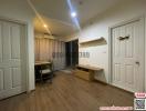 Spacious bedroom with wooden flooring, modern lighting, and built-in shelf