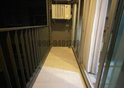 Compact balcony with metal railing and an external air conditioning unit at night