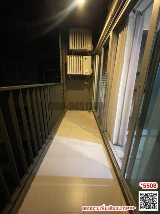 Compact balcony with metal railing and an external air conditioning unit at night