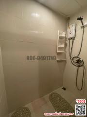 Compact white-tiled bathroom with electric water heater