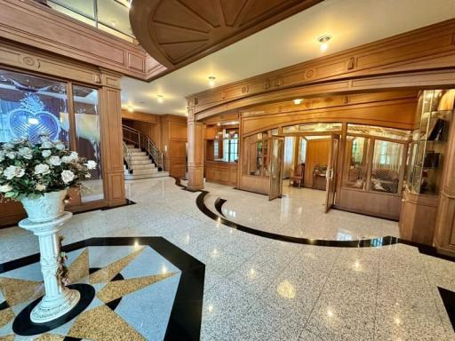 Elegant building lobby with marble floors and ornate wood paneling